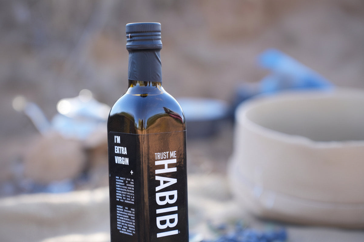 Bottle of Trust Me Habibi olive oil with a blurred background